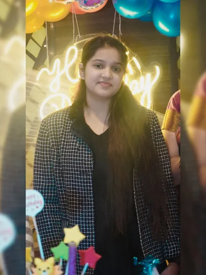 A portrait of a young woman in front of a neon birthday sign. The modern lighting creates a fun and stylish photo opportunity.
