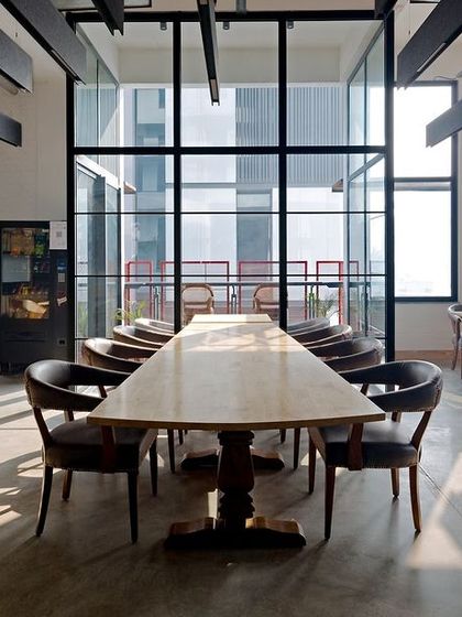 The cafeteria and breakout space at the Visage office is bright and airy, thanks to the full-height windows. The design uses natural materials like wood and stone in their raw forms to establish a tactile connection with nature.