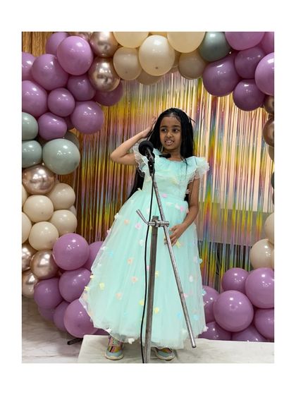 Dressed elegantly, a young performer delivers a moving monologue, holding the audience's attention with her poise.