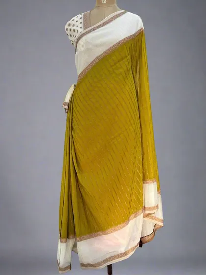 A mannequin draped in the mustard yellow and white semi-wrinkle crepe saree.