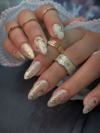 The way the light hits these cat-eye chrome nails is just magical. The almond shape complements the elegant vine artwork.