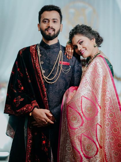 A stylish portrait of the couple at their reception. The groom's elegant sherwani and the bride's shimmering saree are captured in all their glory.