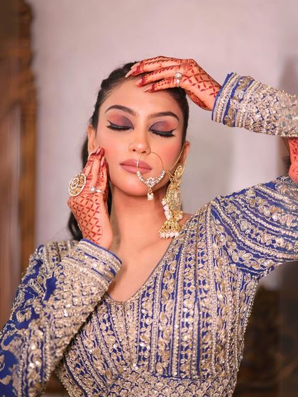 A close-up portrait focusing on the dramatic eye makeup and traditional nose ring.