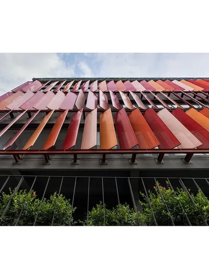 An upward-looking shot of the movable facade panels. This angle highlights the mechanical detail and the rhythmic pattern they create across the building's exterior.