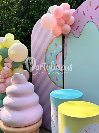 A detailed shot of our ice cream parlor setup. It features a soft-serve prop, sprinkle-covered pedestals, and a donut-themed backdrop, creating a corner that's full of sweet details.