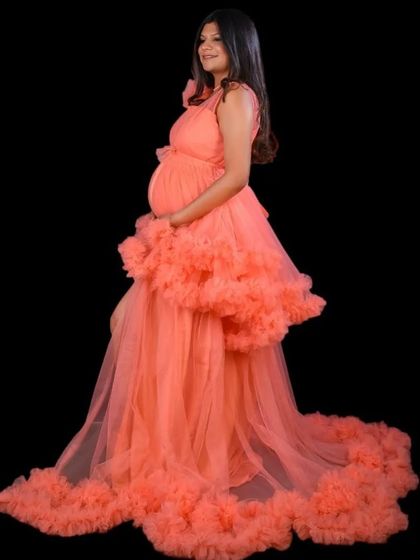 For a high-fashion look, our coral ruffled gown is a perfect choice. It features a thigh-high slit and dramatic ruffles for a bold and confident statement.