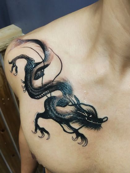 Another angle of the dragon tattoo, showing the flow and shading. This style uses negative space and smoky effects to create depth and a mystical feel.