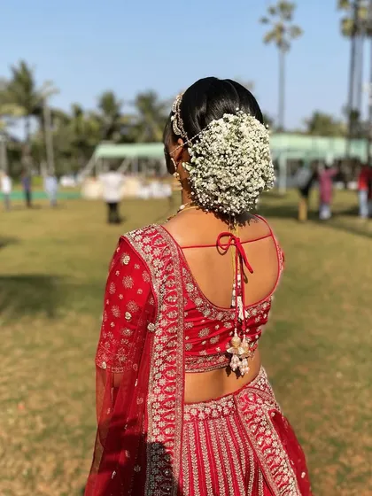 A classic bridal floral bun. I used a full arrangement of baby's breath to create this timeless and romantic look for a bride in a traditional red lehenga.