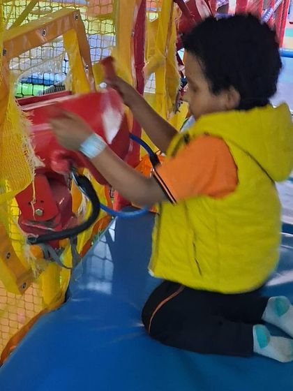 A young explorer operating one of the interactive elements within our play structure. These features encourage imaginative play.