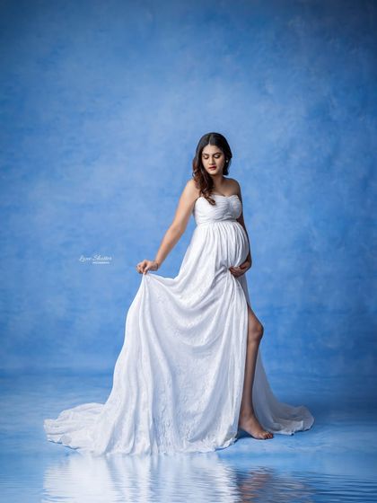 A creative edit with a water reflection, making the white gown and blue backdrop look like a serene lake scene.