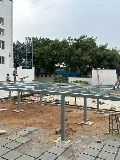 A duplicate image of the pergola installation, showing the team carefully placing the glass panels.