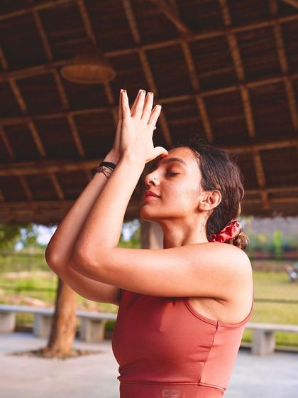 A student in Garudasana (Eagle Pose) arms during a retreat. This pose helps to open the shoulders and upper back, releasing tension and creating a sense of inner space.