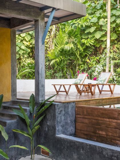 The deck of the private villa, furnished with comfortable lounge chairs for relaxing amidst the sounds of the forest. The space is designed to be a private outdoor retreat.