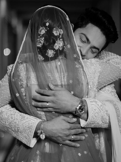 A tender hug after the first look. This black and white photo beautifully captures the emotion and intimacy of the moment.