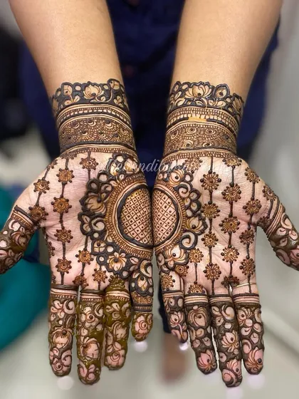 This design is all about symmetry and detail. The central mandala is surrounded by a net of flowers, creating a stunning and intricate look for both hands.
