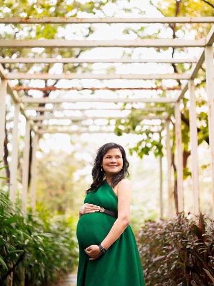 The elegance of motherhood. This mama-to-be in a stunning emerald green gown looks so serene and powerful standing in a beautiful garden path.