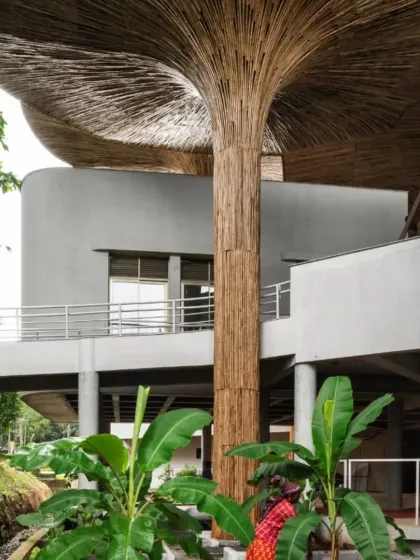 The exterior of the TAPMI Centre shows how the built form integrates with the landscape. Banana plants and other local flora are planted along the edges, grounding the modern structure in its ecological context.