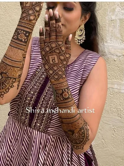 A chic and simple design with the initial 'R' on the back of the hand, perfect for an engagement or sangeet ceremony.