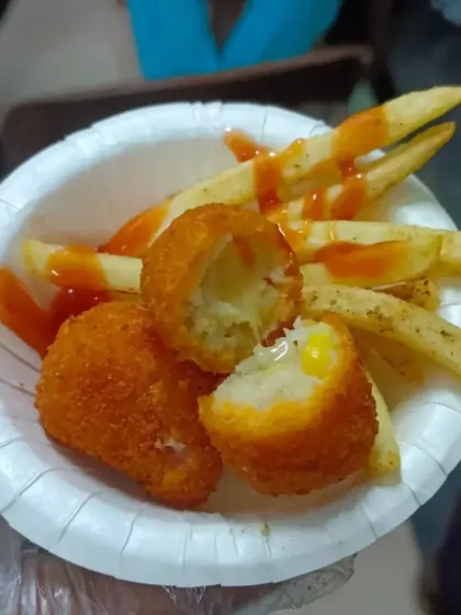 A bite into our Cheese Corn Ball, revealing the gooey, cheesy center. A perfect party snack.