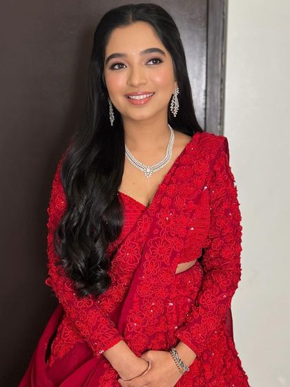 The full look is timeless and chic. The simple, elegant makeup is the perfect partner to a statement red saree.