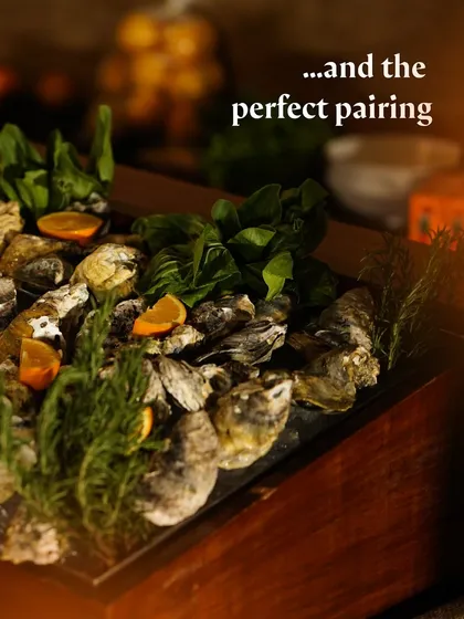 A luxurious display of freshly shucked oysters on ice with citrus wedges.
