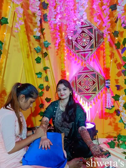 The mehendi ceremony is all about creating beautiful memories. Here I am, applying henna to a bride in a beautifully decorated setting, making her day extra special.