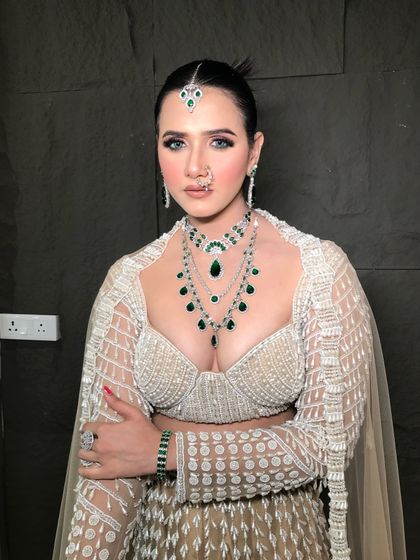 A high-fashion look with a sleek bun and bold makeup, perfect for a modern reception or cocktail event.