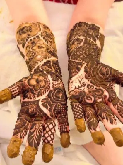 The fresh paste of a heavy bridal design, showing the intricate details and the names of the couple hidden within the pattern.