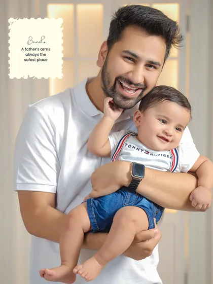 The bond between a father and his child is so special. This portrait captures a simple, happy moment, showcasing the father's pride and the child's cheerful spirit in a warm and inviting studio setting.