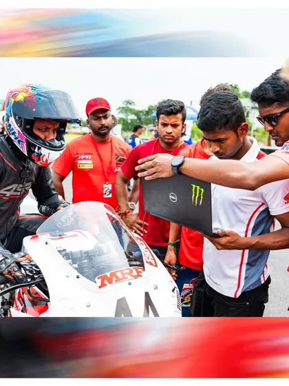 A behind-the-scenes shot of our team analyzing data on a laptop with a rider in the pits.