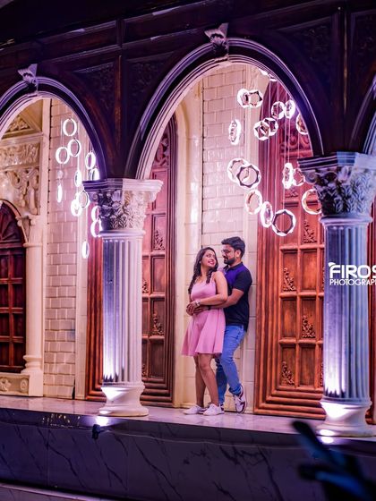 A modern architectural set with hanging ring lights creates a futuristic and stylish backdrop for an evening shoot.