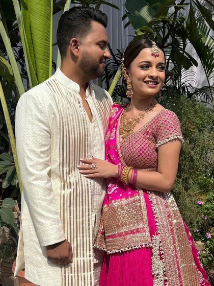 Another angle of this happy couple. The groom's custom-made white kurta provides a clean, elegant canvas that makes the bride's pink lehenga pop.