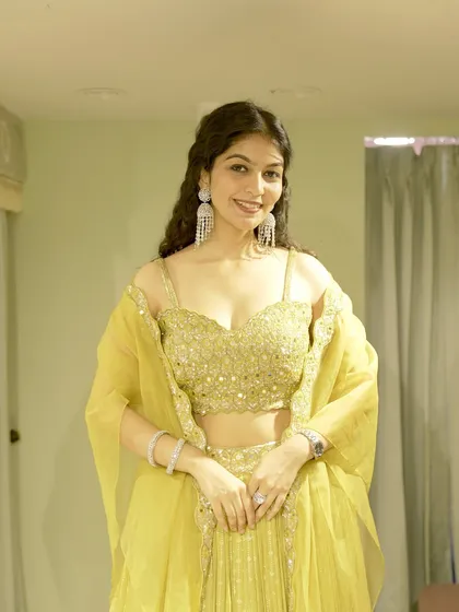 This vibrant yellow lehenga is the perfect example of a look I would curate for a Haldi or Mehendi ceremony. I focus on finding outfits with beautiful details, like the mirror work on this blouse, that make you shine at any celebration.