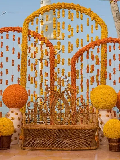 A creative photo-booth backdrop made of marigold balls and floral strings, offering a unique twist on traditional decor.