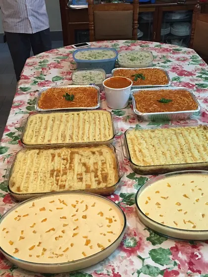 This catering order shows the variety I can offer. It includes multiple trays of Shepherd's pie, spaghetti, creamy mushroom stroganoff, and two large bowls of mango dessert to complete the feast.