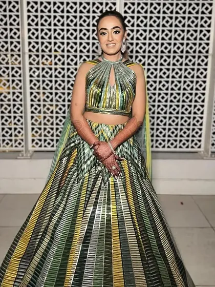 A full-length view showing how the sharp ponytail balances the voluminous, structured lehenga, creating a cohesive and high-fashion silhouette.