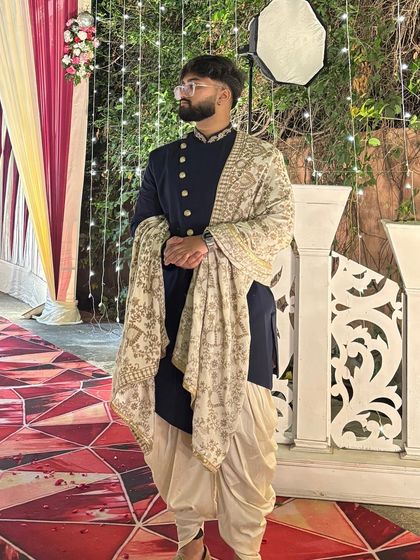 This client is rocking our navy blue Indo-Western outfit with dhoti pants and an embroidered shawl. It's a stylish and comfortable choice for any wedding function.