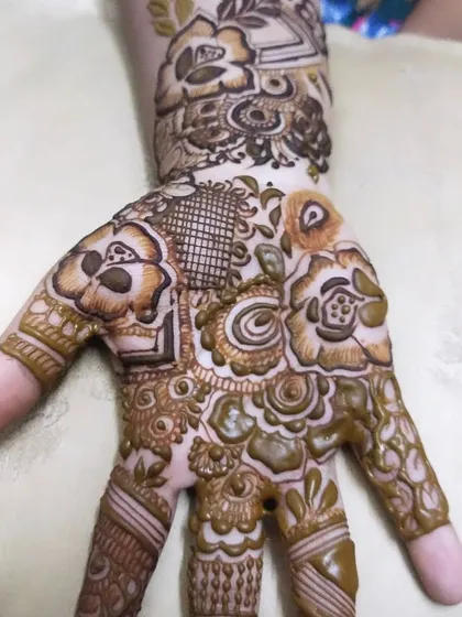 A close-up of a palm filled with a variety of patterns. I love combining different elements like flowers, checks, and swirls to create a unique piece of art.