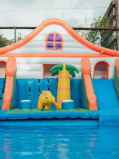 A beautiful shot of an inflatable playhouse in the pool, surrounded by lush greenery, showing how I integrate the party setup with the venue's environment.