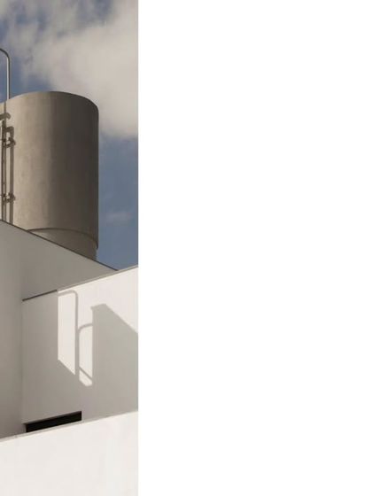 A detail of the rooftop, showing the water tank and access ladder. Even functional elements are designed with a minimalist aesthetic to be consistent with the overall architectural language.