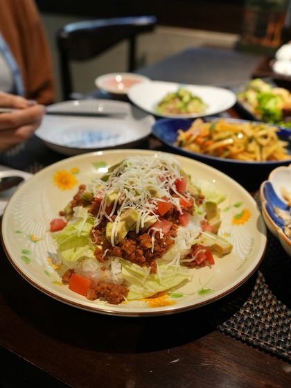 Taco Rice, a unique Okinawan fusion dish. It features seasoned ground pork, lettuce, tomato, and cheese served over a bed of rice, a comforting and flavorful meal.