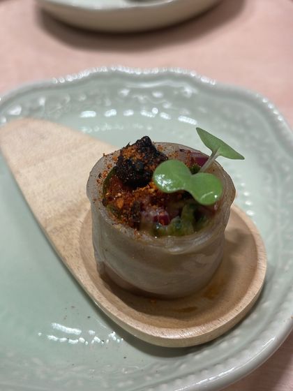 A single, perfectly constructed canapé. This bite features layers of texture and flavor, designed to be enjoyed in one mouthful.