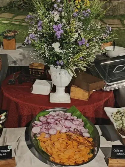 A beautiful spread of fresh salads and appetizers for an outdoor event. We use quality ingredients to create a diverse menu, including healthy and light options alongside main courses.