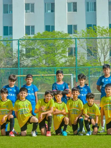 A youth team poses for a group photo with their coach, proud and united after a successful tournament.