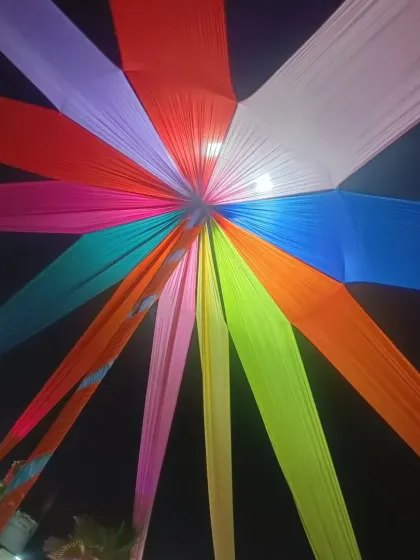 This colorful fabric canopy is one of my signature designs for outdoor or large indoor spaces. Using vibrant strips of cloth radiating from a central point, I can instantly transform a ceiling and add a festive, energetic feel to any corporate event or party.