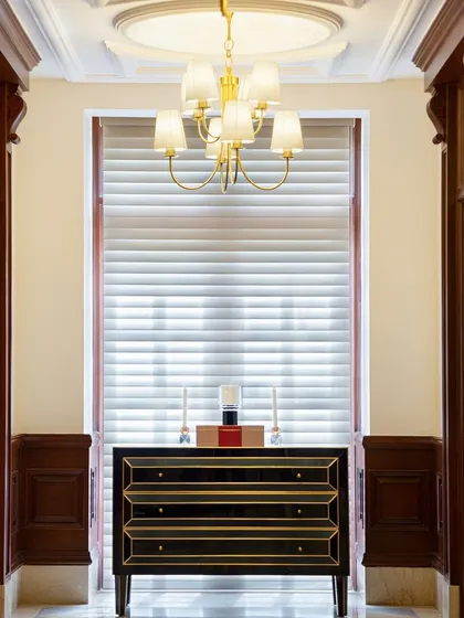 We retained and highlighted the original architectural details of The Imperial Hotel in our design. The classic wooden architraves and a traditional chandelier are complemented by a modern, black lacquered console, showcasing how old and new can coexist beautifully.