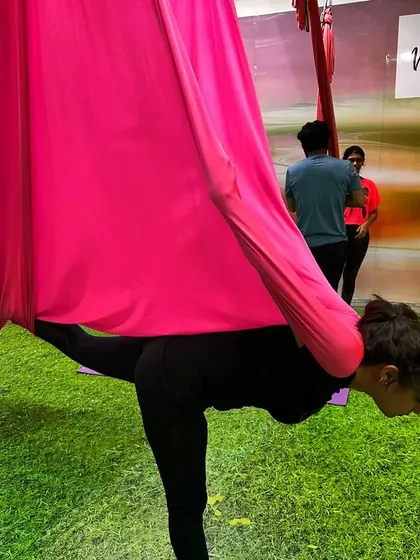 Explore your aerial journey with us. This student is using the hammock for a supported warrior pose, building strength and focus.
