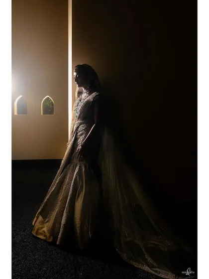 A dramatic, low-key portrait of the bride, Nandini. The play of light and shadow in this black and white image creates a mysterious and elegant mood.