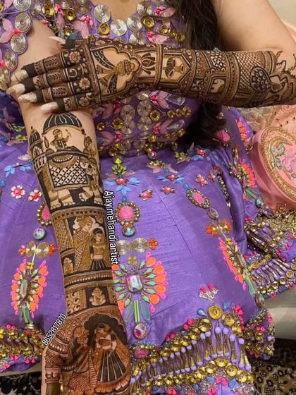 A close-up of the bride's arm, showing the detailed story-telling design featuring a wedding procession with an elephant.