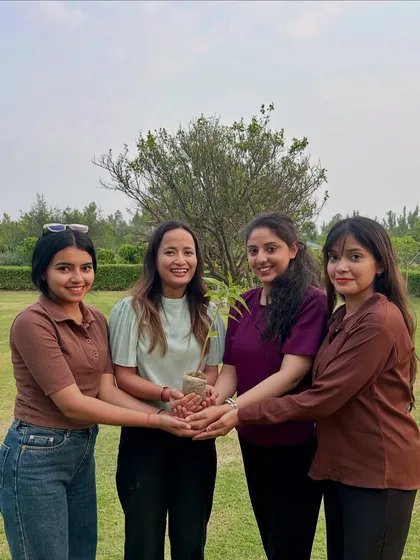 Holding a new life in our hands. Our team members come together to hold a sapling, symbolizing our collective commitment to protecting and nurturing our planet for a sustainable future.